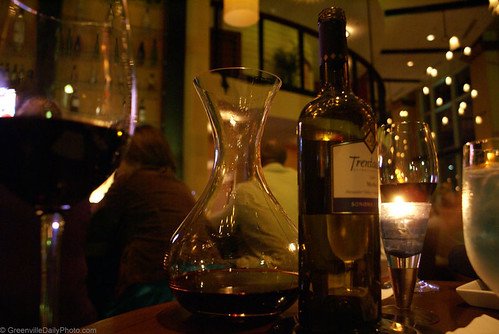 Wine bottle, decanter and glasses on a candlelit table