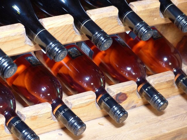 Rosé bottles resting in a wooden wine rack